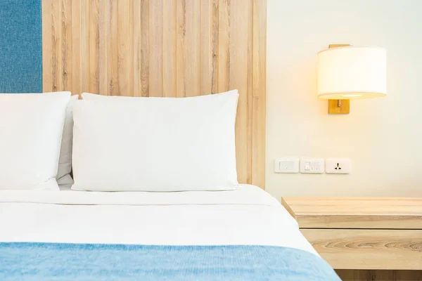 Белая удобная подушка на кровати с легким лампом — стоковое фото