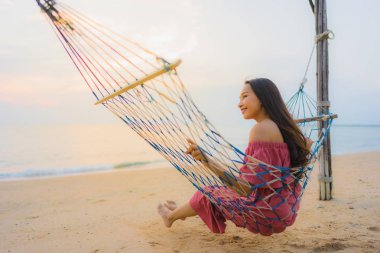 Dikey hamak ile oturan güzel genç Asyalı kadın