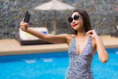 Portre güzel asya kadın açık çevresinde cep telefonu kullanarak