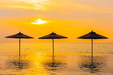 Şemsiye ve sandalye yüzme havuzu yakınında deniz okyanus plaj