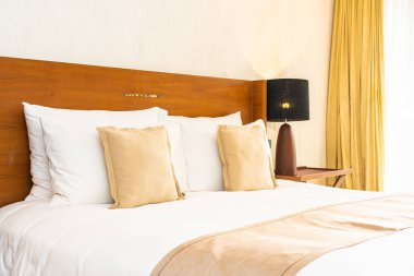 Yatak üzerinde güzel konforlu lüks beyaz yastık ve battaniye Dec