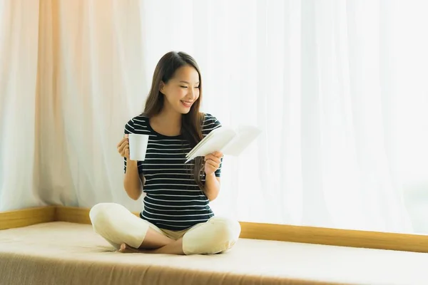 Retrato hermosa joven asiática mujer leyendo libro y celebrar café —  Fotos de Stock