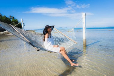Portre güzel genç Asyalı kadın etrafında hamak üzerinde oturuyor s
