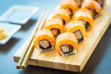 Somon Balık et suşi roll maki ahşap plaka üzerinde