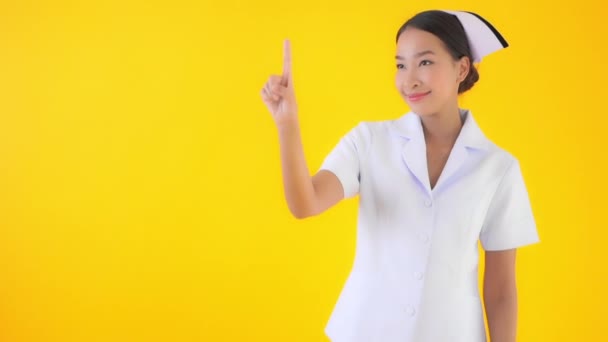 黄色を指差す美しいアジア系女性医師の映像 — ストック動画