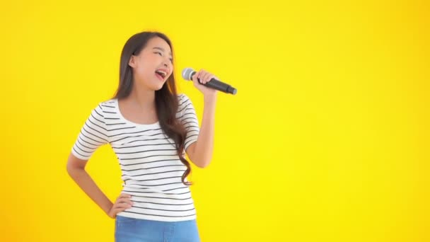 美丽的亚洲女人用黄色话筒唱歌的镜头 — 图库视频影像