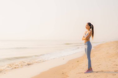 Portre sporu genç Asyalı kadın egzersiz hazırlıyor ya da sağlık için okyanusta koşuyor.