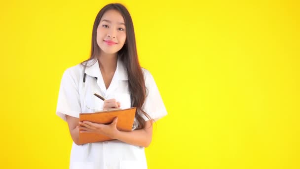 クリップボードに美しいアジア系女性医師の文章の映像 — ストック動画