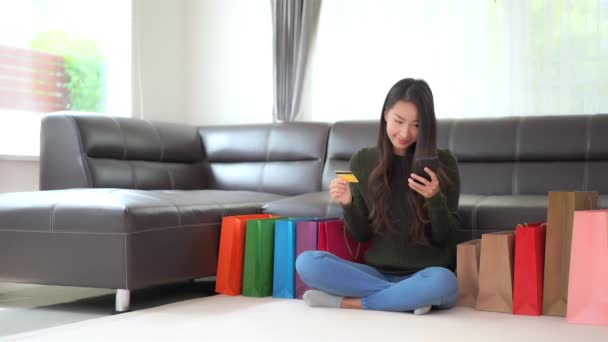 美丽的亚洲女人在家里提着彩色购物袋的镜头 — 图库视频影像
