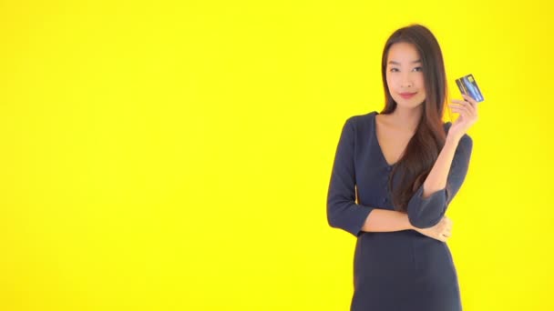黄色のクレジットカードを持っている美しいアジアの女性の映像 — ストック動画