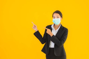 Güzel genç iş kadını portresi Korunmak için maske takıyor 19 koronavirüs sarı izole arka planda