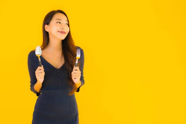 노란색외진 배경에서 준비가 숟가락과 포크를 아름다운 아시아 여자의 — 스톡 사진