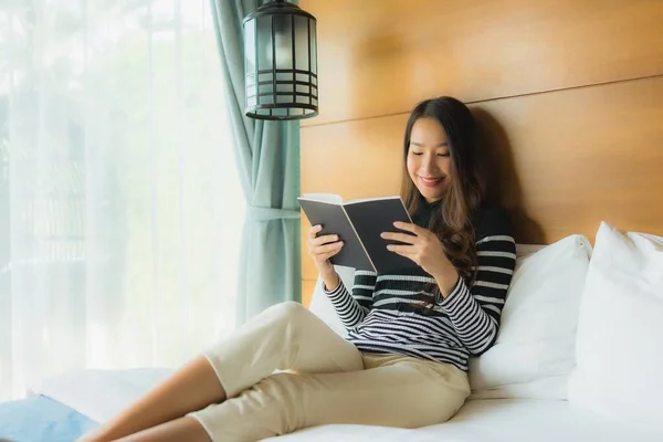 Portrait young asian woman read book in bedroom interior