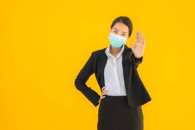 Güzel genç iş kadını portresi Korunmak için maske takıyor 19 koronavirüs sarı izole arka planda