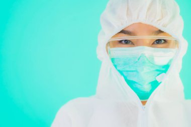 Güzel, genç Asyalı doktor kadın portre. Koronavirüsten ya da mavi arka planda kovid19 'dan korunmak için ppe ya da kişisel koruyucu ekipman takıyor.