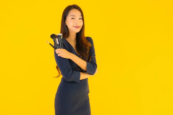 Portrait Beautiful Young Asian Woman Makeup Brush Yellow Isolated Background — Stock Photo, Image