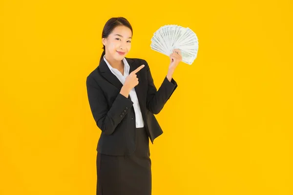 美しいですポートレート若いですアジアの女性とともにたくさんのお金現金上の黄色隔離された背景 — ストック写真