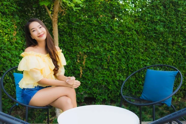 年轻的亚洲女人开心的笑着放松 坐在椅子上环绕着户外的自然景观 — 图库照片