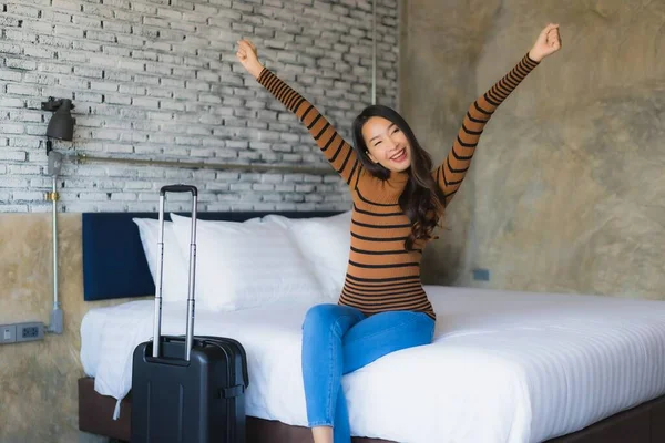 Young asian woman with luggage bag in bedroom interior