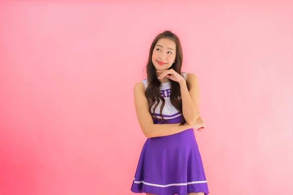 年轻美丽的亚裔女子啦啦队队长笑着 带着淡淡的粉红背景 — 图库照片