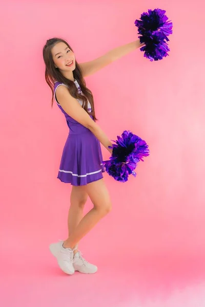 Portrait beautiful young asian woman cheerleader smile happy on isolated pink background