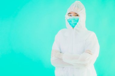 Güzel, genç Asyalı doktor kadın koronavirüsten korunmak için ppe ya da kişisel koruyucu ekipman takıyor ya da mavi izole arka planda beyaz kartı olan 19. bölgede yaşıyor.