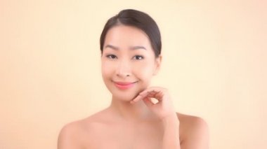 Bej arka planda açık tenli güzel bir Asyalı kadının görüntüleri.