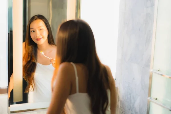 肖像画美しい若いアジアの女性バスルームのインテリアで歯を磨く — ストック写真