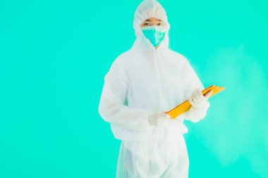 Güzel, genç Asyalı doktor kadın koronavirüsten korunmak için ppe ya da kişisel koruyucu ekipman takıyor ya da mavi izole arka planda beyaz kartı olan 19. bölgede yaşıyor.
