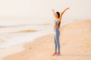 Portre sporu genç Asyalı kadın egzersiz hazırlıyor ya da sağlık için okyanusta koşuyor.