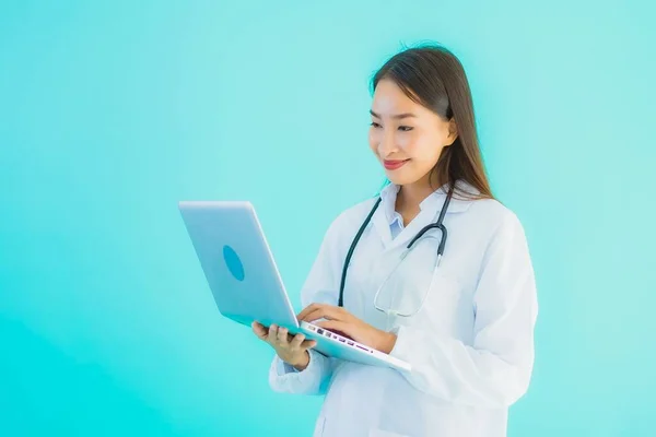 形象漂亮的年轻亚洲医生妇女 有手提电脑 可在诊所或医院使用 背景是蓝色孤立的 — 图库照片