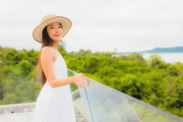 年轻美丽的亚洲女子在有海景背景的阳台上快乐地笑着 — 图库照片
