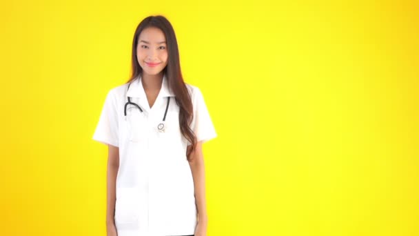 Metraje Hermosa Joven Asiática Médico Blanco Uniforme Aislado Amarillo — Vídeos de Stock