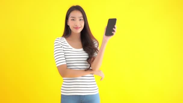 Närbild Bilder Vackra Unga Asiatiska Kvinna Med Smartphone Isolerad Gul — Stockvideo