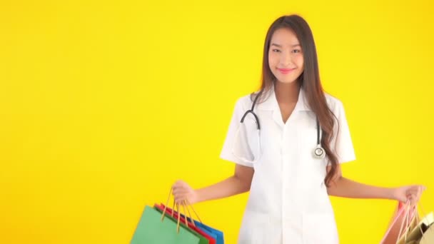 Záběry Krásné Mladé Asijské Lékař Drží Barevné Papírové Tašky Bílé — Stock video