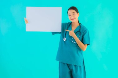 Fotokopi için boş kâğıt tahtası olan güzel Asyalı genç doktor kadın hastane ve klinikteki sağlık hizmetleri konseptinde mavi izole edilmiş arka plan.