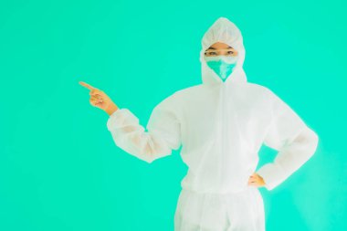 Güzel, genç Asyalı doktor kadın portre. Koronavirüsten ya da mavi arka planda kovid19 'dan korunmak için ppe ya da kişisel koruyucu ekipman takıyor.