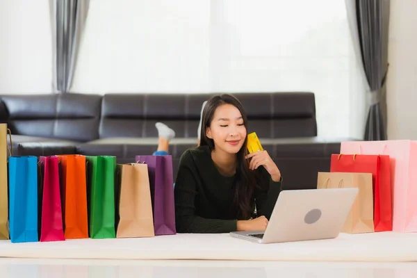 亚洲年轻貌美的女人 带着购物袋和信用卡 带着手机在家网上购物 — 图库照片