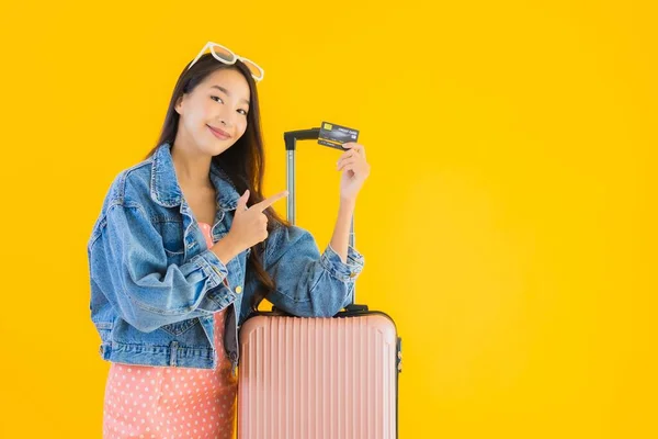 亚洲年轻貌美的女子 头戴旅行袋 头戴护照 背景为黄隔离的登机牌 — 图库照片