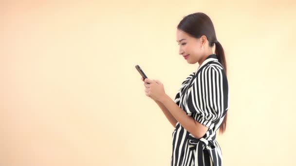 Sarıda Izole Akıllı Telefon Kullanan Çizgili Takım Elbiseli Güzel Asyalı — Stok video