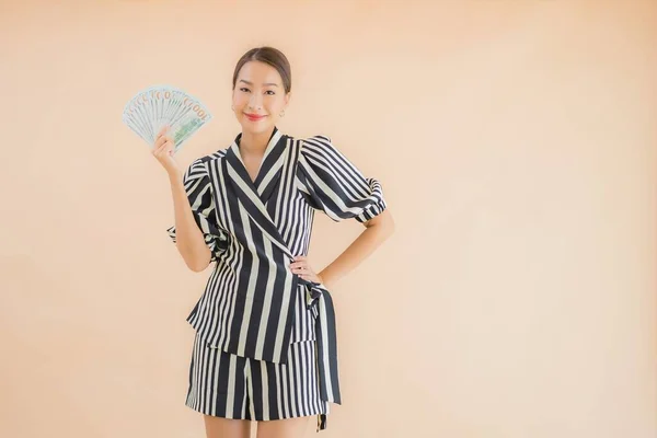 Kahverengi Arka Planda Parası Parası Olan Güzel Bir Asyalı Kadın — Stok fotoğraf