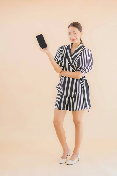 Kahverengi Arka Planda Akıllı Cep Telefonlu Güzel Asyalı Kadın Portresi — Stok fotoğraf