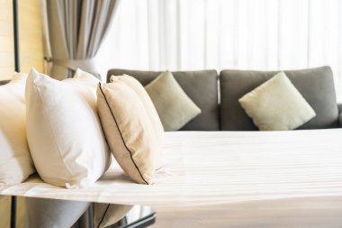 Otel odasındaki yatak odasının iç dekorasyonunda beyaz rahat yastık.