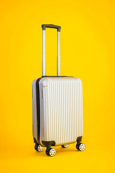 Gray color luggage or baggage bag use for transportation travel and leisure on yellow isolated background