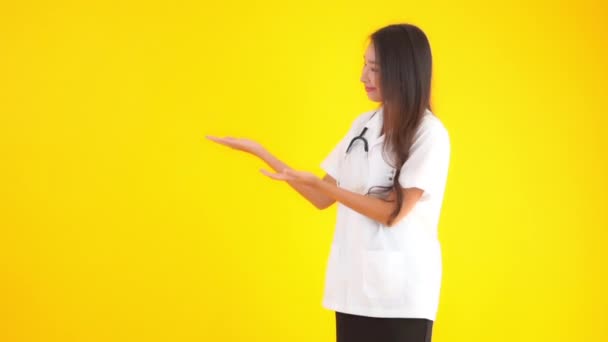 Metraje Hermosa Joven Asiática Médico Blanco Uniforme Aislado Amarillo — Vídeos de Stock