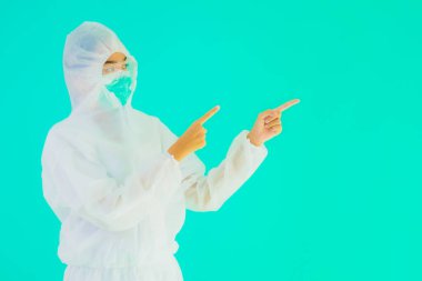 Güzel, genç Asyalı doktor kadın portre. Koronavirüsten ya da mavi arka planda kovid19 'dan korunmak için ppe ya da kişisel koruyucu ekipman takıyor.