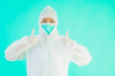 Güzel, genç Asyalı doktor kadın portre. Koronavirüsten ya da mavi arka planda kovid19 'dan korunmak için ppe ya da kişisel koruyucu ekipman takıyor.