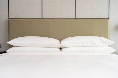 Yatak odasının içi beyaz, rahat yastık ve battaniye dekorasyonu.