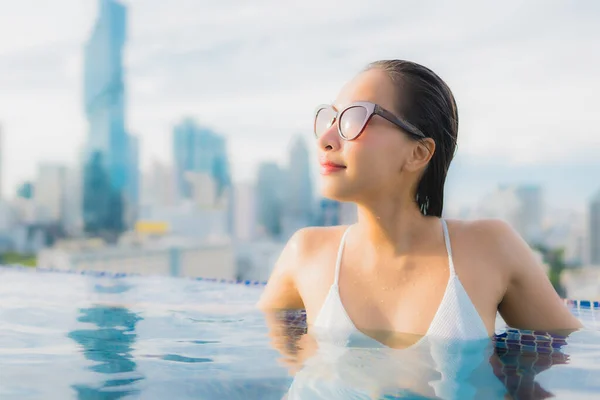亚洲年轻貌美的女子在户外游泳池和城市景观中悠闲自在地笑容满面 — 图库照片