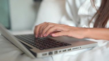 Evde dizüstü bilgisayarla çalışan Asyalı güzel bir kadının görüntüleri.